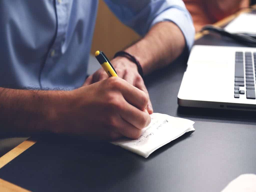 A man making a moving checklist on a piece of paper.