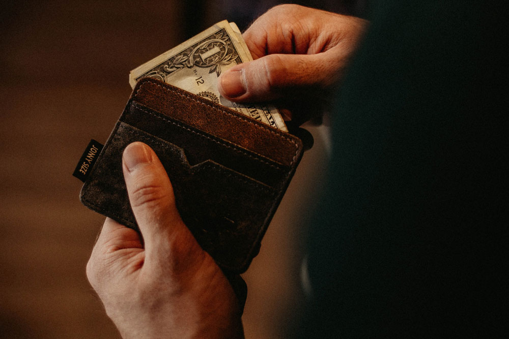 Person taking a dollar bill out of their wallet