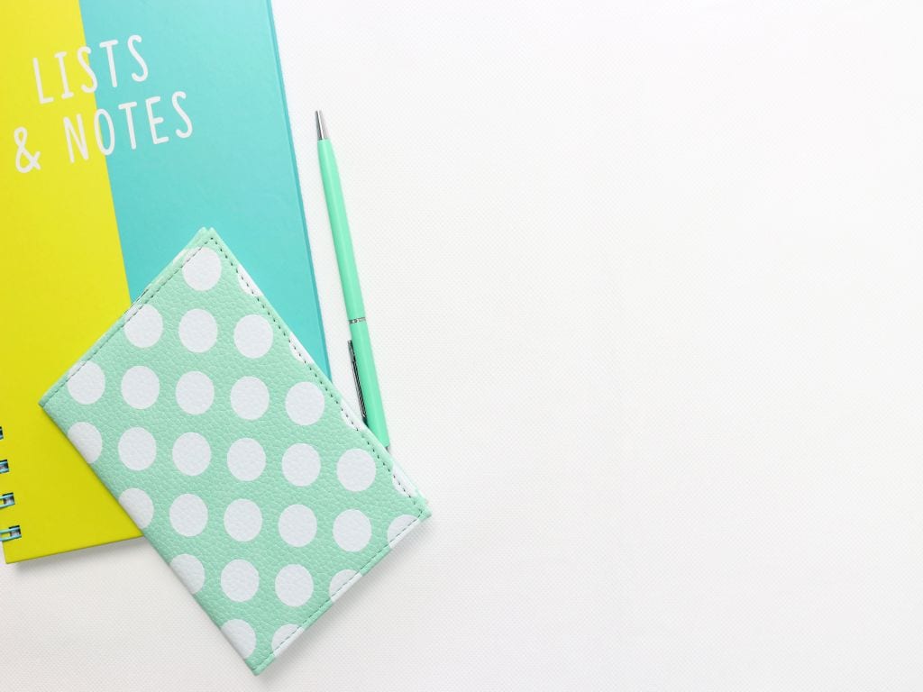 A brightly colored notebook on a white surface, where you'll make a post-moving checklist.