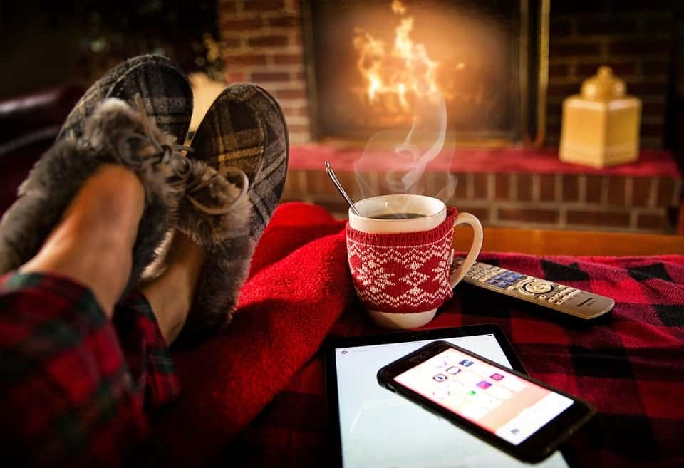 A person sitting next to a fireplace and enjoying his living room after home redecoration