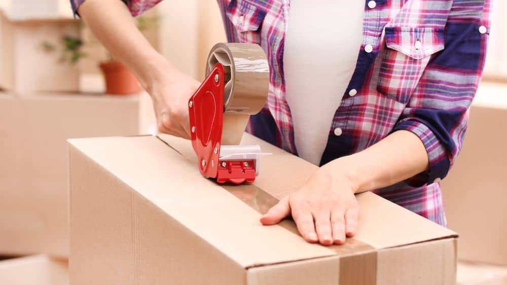 Person using tape to close a moving box