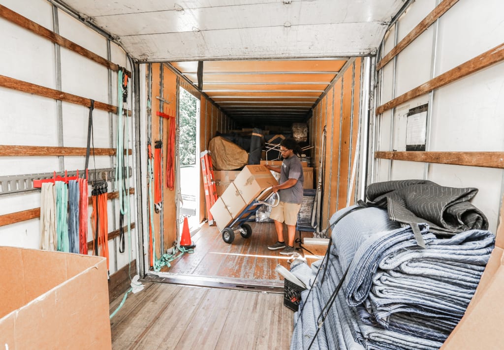 Interior of a moving truck with a mover carrying boxes into it