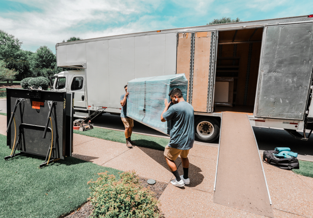Two Move On movers unloading an item out of a moving truck to a home