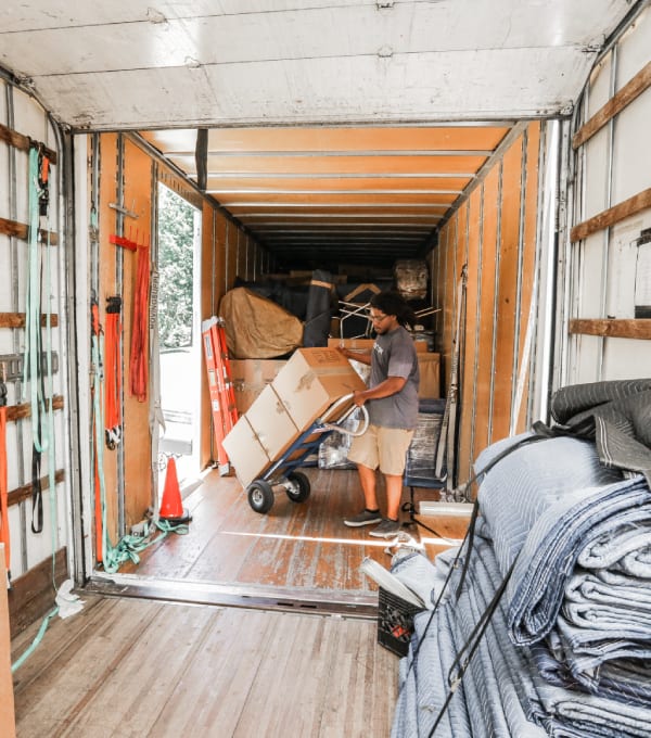 Interior of a moving truck with a mover carrying boxes into it