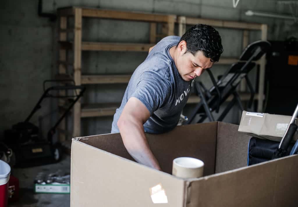 Move On mover placing items into a box in a Nashville homeowner's garage